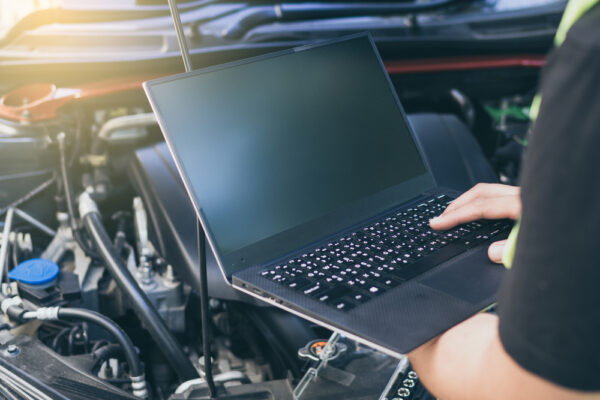 Close up engineer  mechanic using electrnoic diagnostic equipment to tune a car